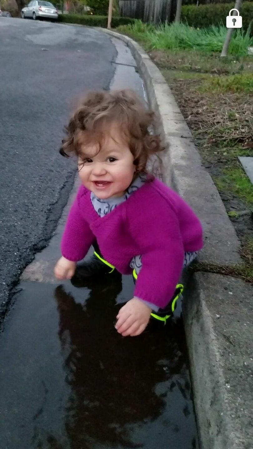 toddler playing in puddles